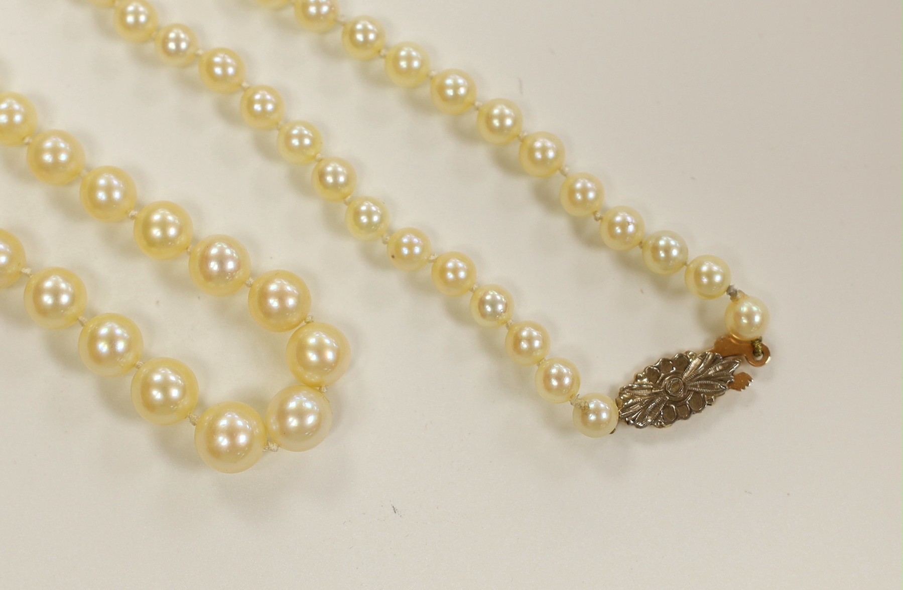A single strand graduated cultured pearl necklace, with rose cut diamond set yellow metal clasp, 52cm.